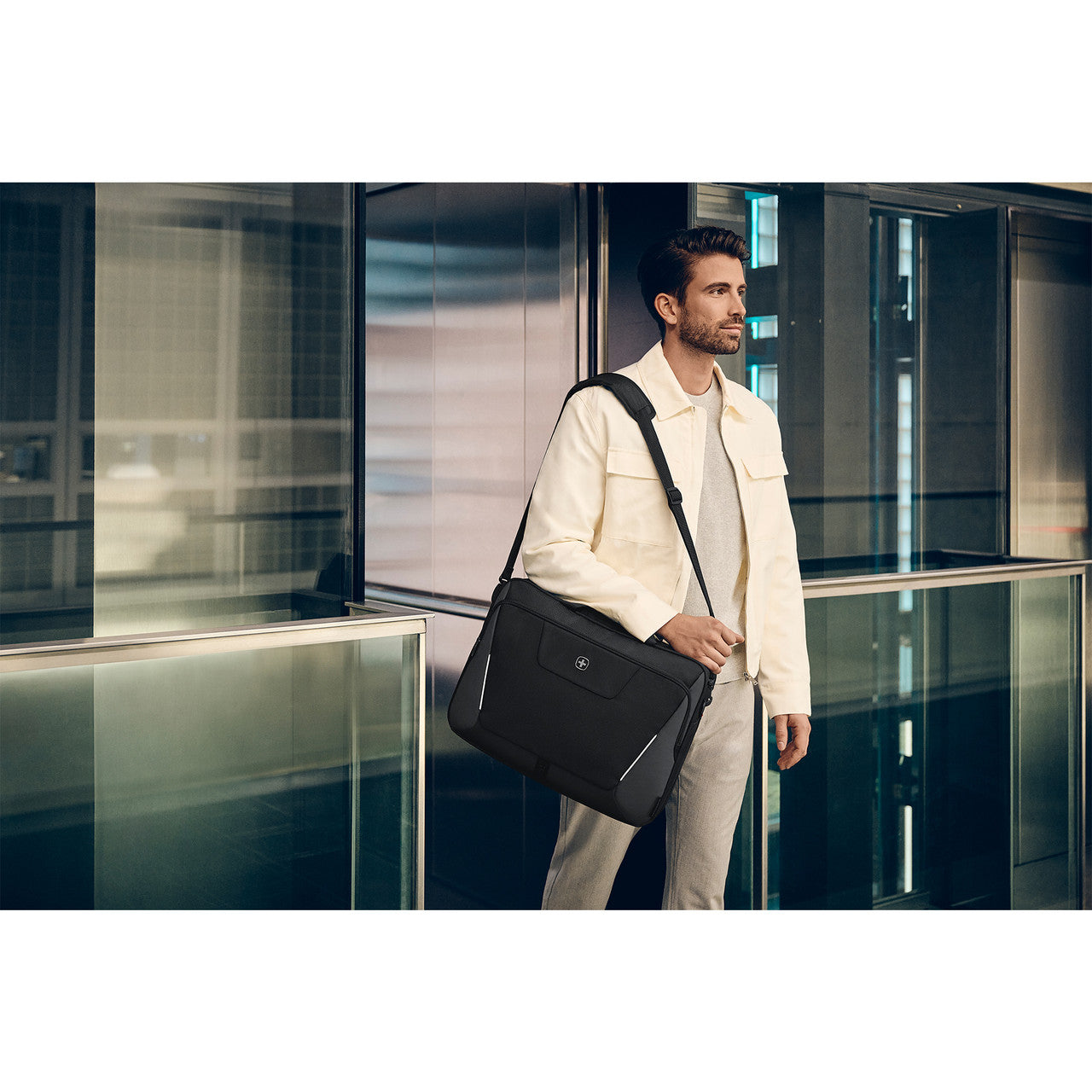Man carrying a black briefcase in an indoor setting